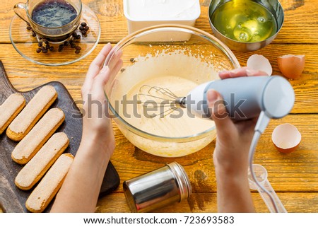 Image of human with whisk cooking dessert