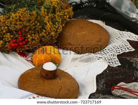 Autumn still life - loaf, pumpkin, mountain ash, tansy, wheat ears, salt,
on a white tablecloth with lace