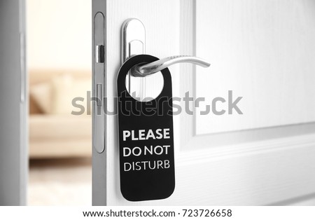 Open door with sign PLEASE DO NOT DISTURB on handle at hotel Royalty-Free Stock Photo #723726658