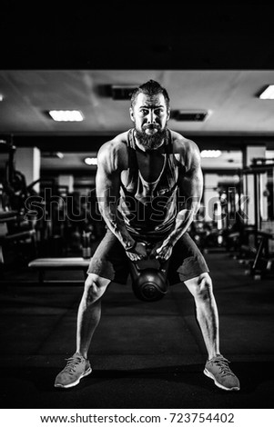 Fitness Kettlebells swing exercise bearded man workout at gym