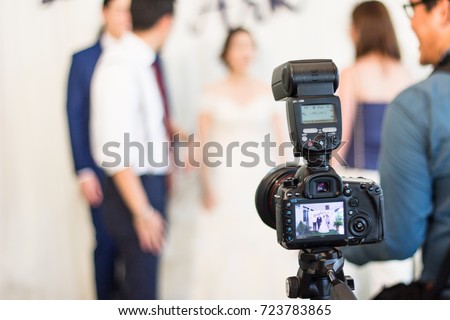 Behind the scenes of camera, Photographer is taking photo of wedding ceremony. Blur background.