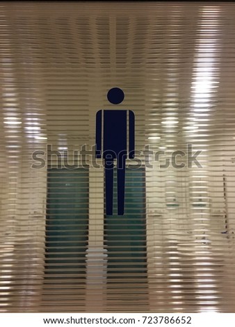 Male toilet sign blue on a glass door
