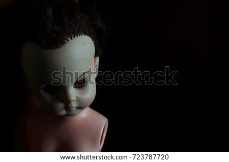 creepy doll bend down the head in high contrast