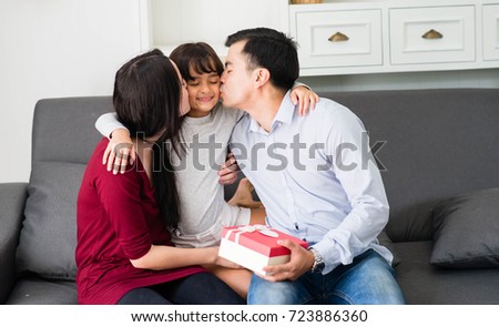 Happy family with daughter relaxing in sofa and gift for spacial day. Good family relationships, happiness, trust and smile.