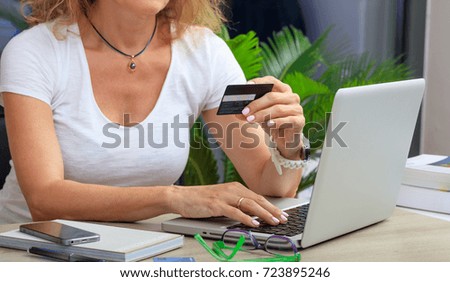 Online shopping concept. Woman holding a credit card in an office background