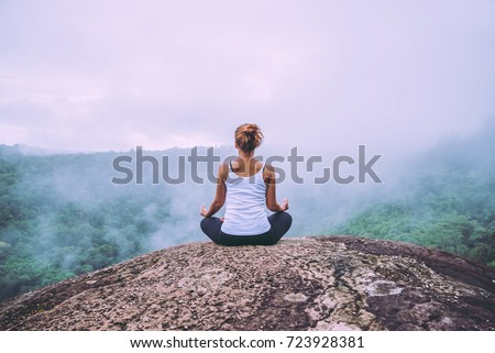 Asian women relax in the holiday. Play if yoga. On the Moutain rock cliff Royalty-Free Stock Photo #723928381