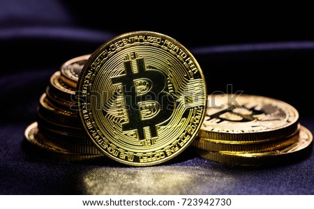 Golden shining bitcoins stacked on black background