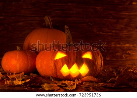 thre evil halloween pumpkins on wooden background, copy space -