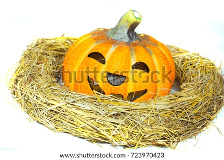 Halloween pumpkin with smiley face in straw wreath isolated on white background. Autumn and harvest season. Holiday celebration concept.