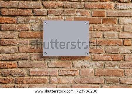 Empty information sign on old brick wall. Grey color