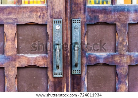 Closeup of vintage wooden door handles showing symmetry, pattern and texture