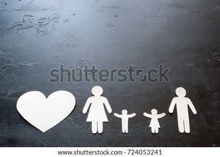 paper family and heart on a black background with space for text