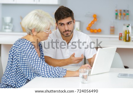 grandmother and grandson watching family pictures on laptop