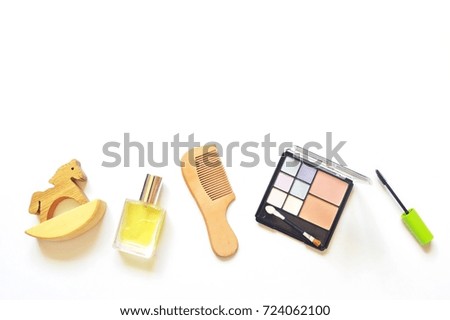 Toy wooden horse, perfume bottle, hair brush, eyeshadow and mascara. Flat lay beauty products, top view photo. Free space for text. Makeup accessories. Mockup for beauty blog