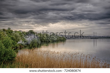 Cloudy sky over the river. Dry reeds. Dnipro River. Ukraine.