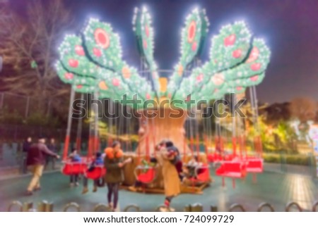 Defocused background of a chair swing ride inside an amusement park. Intentionally blurred post production for bokeh effect