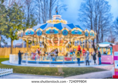 Defocused background of an old fashioned carousel in amusement park at dusk