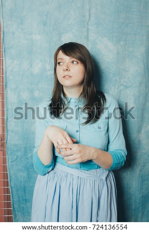 young girl in a light blouse and long skirt posing in a photo Studio. a gentle way. emotional portrait. dreamy woman. clean skin and long hair