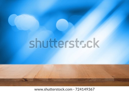 Wooden desk with blue gradient tone abstract background bokeh circles for Christmas background.