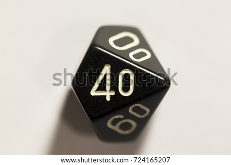 Top-down view of a black ten-sided die, showing the number forty.