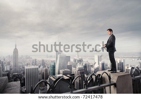 Businessman throwing some banknotes from a skyscraper
