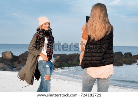 Friends. Girls take picture on the beach in autumn
