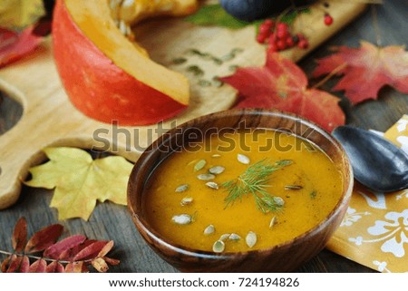 pumpkin soup in a wooden bowl against the background of autumn leaves. autumn dish. style rustic.