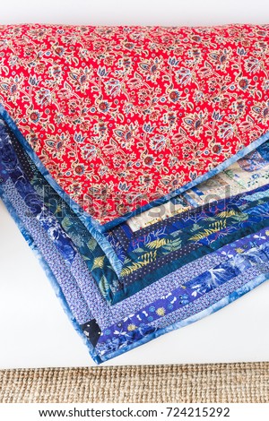 quilting, piecework, homemade, culture, interior, needlework concept - two blankets made in russian technique patchwork with contrast red and blue ornate material Royalty-Free Stock Photo #724215292