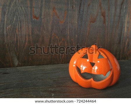Close up on pumpkin ghost on old red wood table.