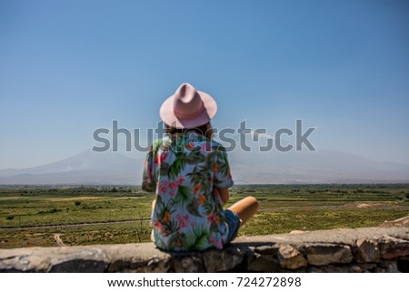 Girl in a pink hat, looking at mountain Ararat from the Khor Virap monastery 
