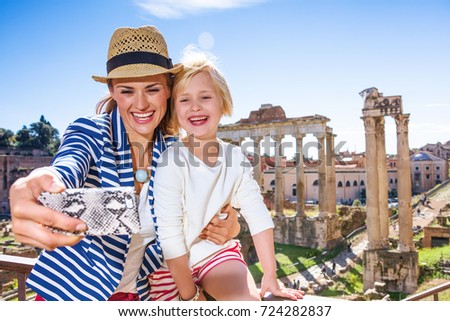 Roman Holiday. smiling modern mother and child tourists against Roman Forum in Rome, Italy with phone taking selfie