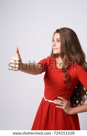 Gesture approval. Portrait girl. Red dress. Brunette.