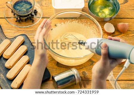 Photo of man with whisk preparing dessert of cookies