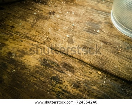 Dirty wooden floor, place a glass of water.