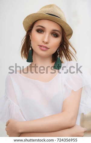 Beautiful tourist woman with jewelery earrings brushes on summer vacation copy space