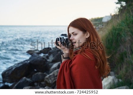 woman photographer in a plaid photographing nature, the sea                               