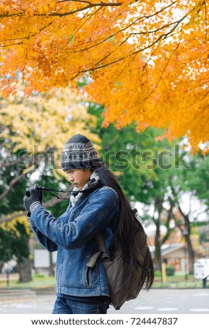 Asian man take a photo with digital camera in the park.