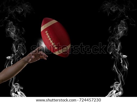 Digital composite of finger touching american football  in smoke