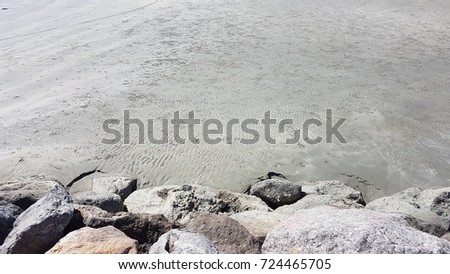 Rock coastal beach view,dirty rock at the seaside sand