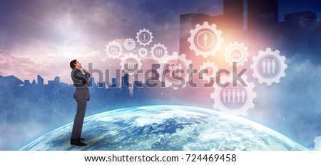 Thoughtful businessman holding pen to chin against picture of the earth