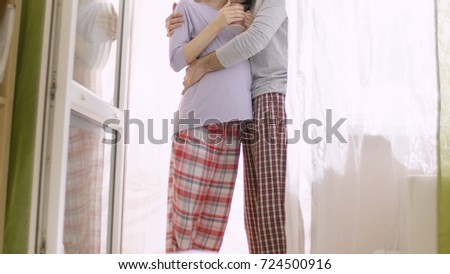 Loving husband gently hugging his pregnant wife. Happy family in anticipation of the birth of the baby