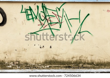 Surface of street wall with spots of abstract graffiti drawings in style of tag graffiti. wall is completely covered with graffiti-tags. Abstract colored drawings, letters. City culture. Street art
