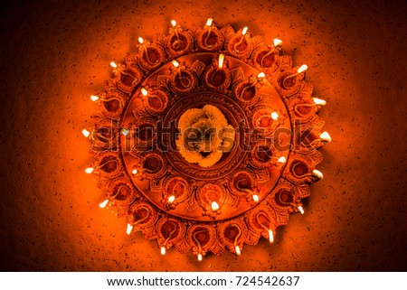 Beautiful illuminated terra-cotta Diwali diya Plate in the night, moody lighting, selective focus Royalty-Free Stock Photo #724542637