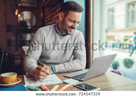 Businessman having coffee and doing his work in cafe. Royalty-Free Stock Photo #724547359