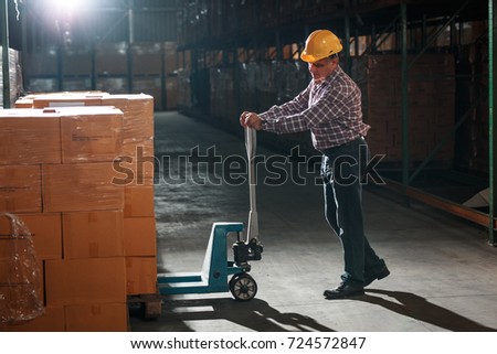 Warehouse worker selecting packages at the storehouse.Night shift. Royalty-Free Stock Photo #724572847