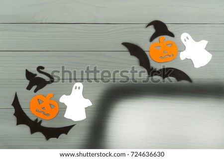 Top view of Halloween paper silhouette of different characters made of horizontal frame on grey wooden background. Halloween holiday concept. Copy space
