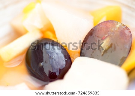 Fresh and healthy tropical fruit salad with pieces of grapes, apples and peach