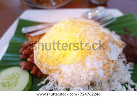 Malaysia traditional foods, Nasi Lemak or fragrant rice cooked in coconut milk with fried egg on banana leaf background
