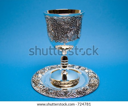Silver kiddush wine cup and saucer on the blue background