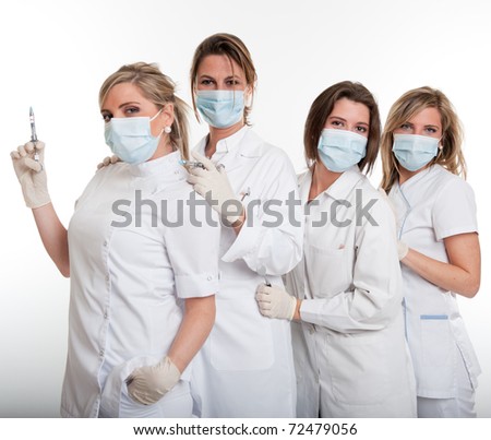 Four female dentists posing with masks and equipment